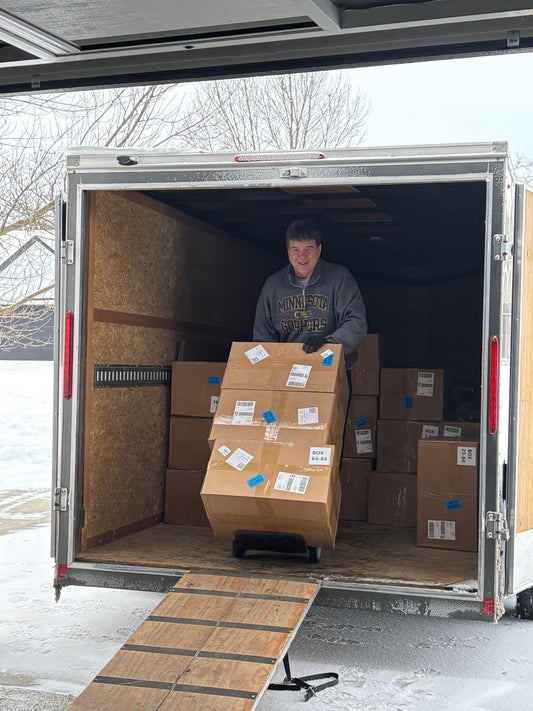 Jack unloading QuickSet adjustable bike seat boxes from truck during production delivery