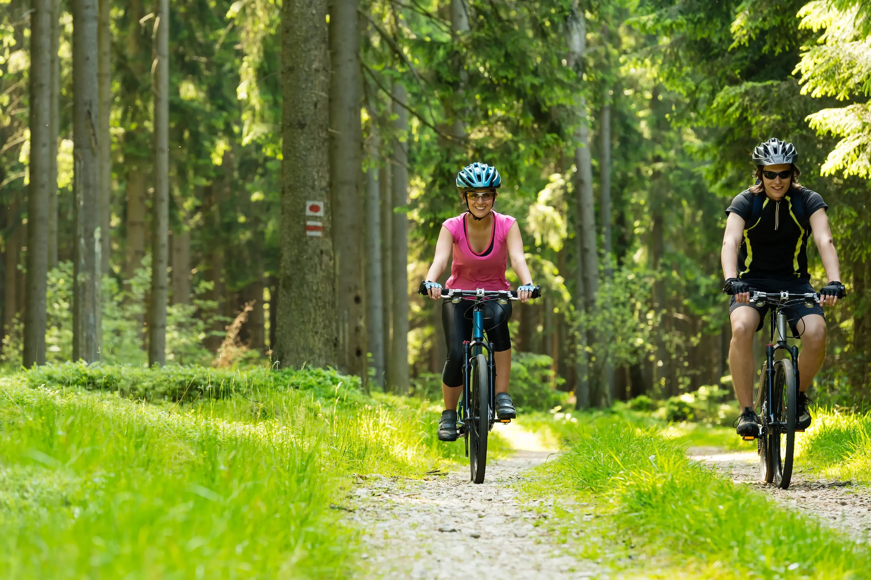 Active riders testing adjustable bike seat on wooded path
